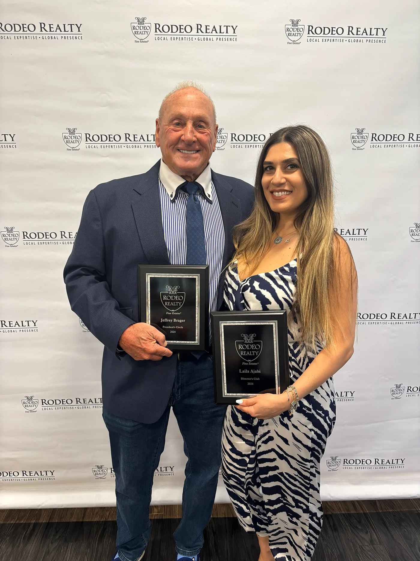 Jeffrey with a young woman both holding an award.